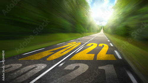 The new year 2022 future arrives at high speed road - 2021 goes by - Freedom on vacation travel trip.