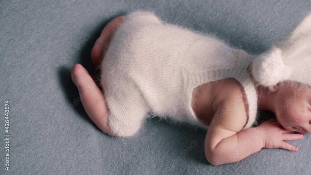 A newborn boy in a woolen cap sleeps sweetly. Close-up, slider shot. A newborn boy in a woolen cap sleeps sweetly. Close-up, slider shot.