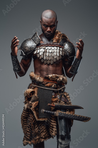 Valokuva Authentic african barbarian prays with raised hands in gray background