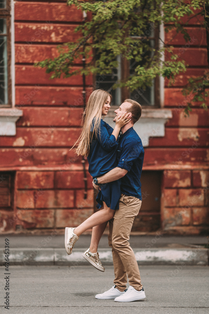 Happy couple in love walks the city streets together. A lovely couple on the old narrow streets of the city. Lifestyle of smiling people. Family relations concept Happy couple in love walks the city streets together. A lovely couple on the old narrow streets of the city. Lifestyle of smiling people. Family relations concept