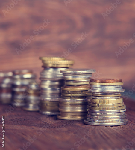 Coins on the background of mahogany. Stacks of coins of different nominal value. Concept - advertising about the bank or finances company.