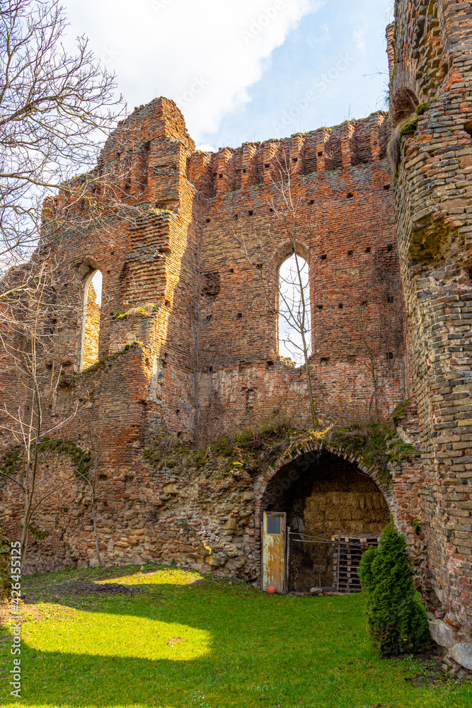 Ruined walls of a medieval citadel fortress. Cracked brick walls and decaded window arches can be seen in the photo. Citadel walls in ruin with arches and collumns.