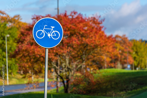 Bicycle path sign with autumn trees in the background..