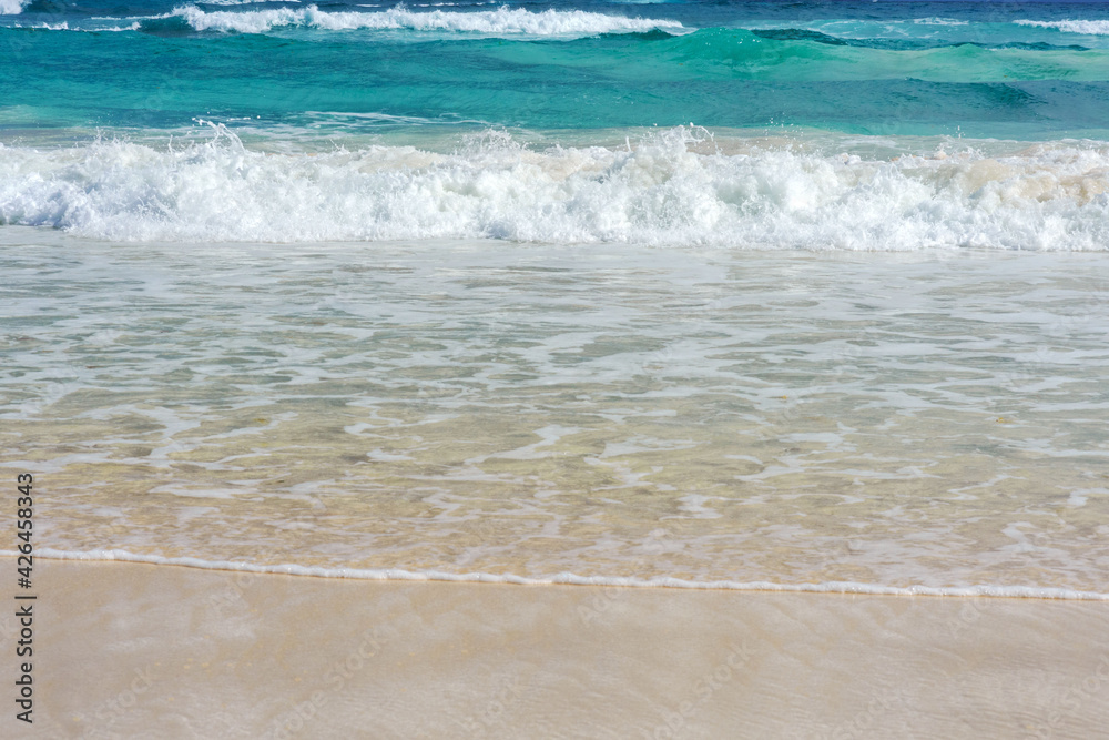 A foamy wave runs over the sandy beach. Seascape turquoise ocean and sandy coast against the blue sky. Rest by the sea. Exotic island. A foamy wave runs over the sandy beach. Seascape turquoise ocean and sandy coast against the blue sky. Rest by the sea. Exotic island.