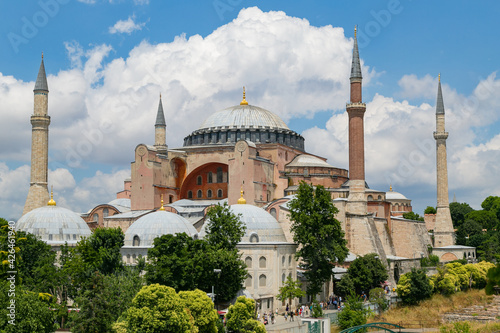 Hagia Sophia in summer, Istanbul, Turkey. The world famous monument of Byzantine architecture, imperial mosque and now a museum. View of the St. Sophia Cathedral with cloudy sky and green trees.