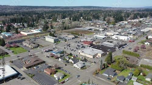 Orbiting cinematic aerial drone shot of downtown Marysville, by the I-5 freeway, a distant suburb, bedroom community North of Seattle on the shores of Puget Sound in Washington photo