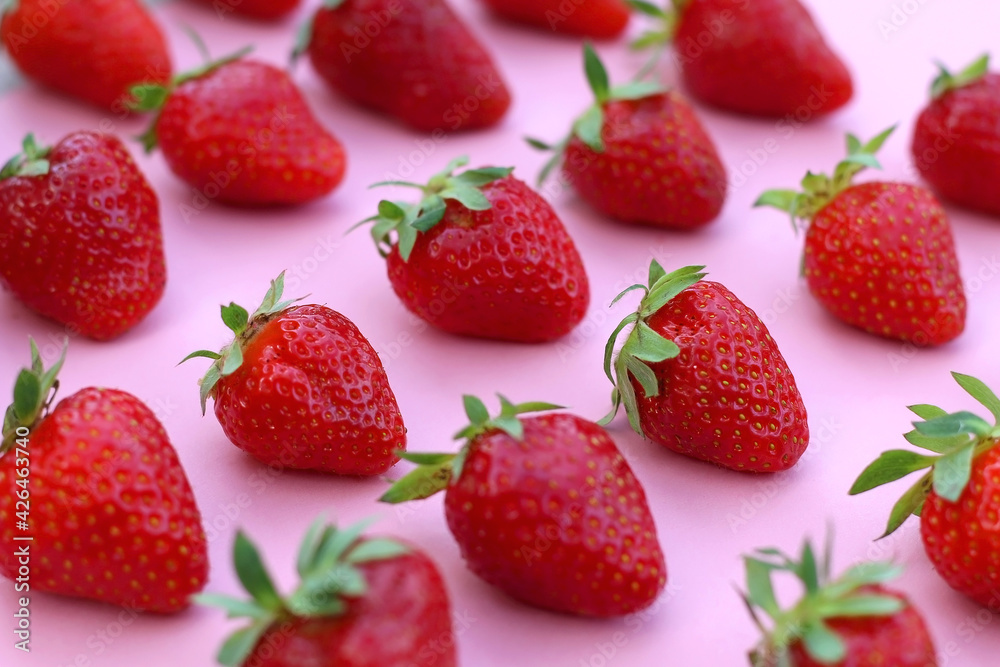 Fresh strawberries organized on pink background. Selective focus. Fresh strawberries organized on pink background. Selective focus.