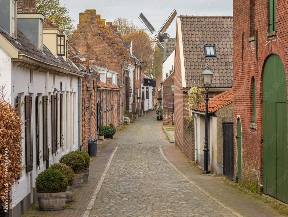 Picturesque street leading to the old windmill in the town of Buren, Betuwe region