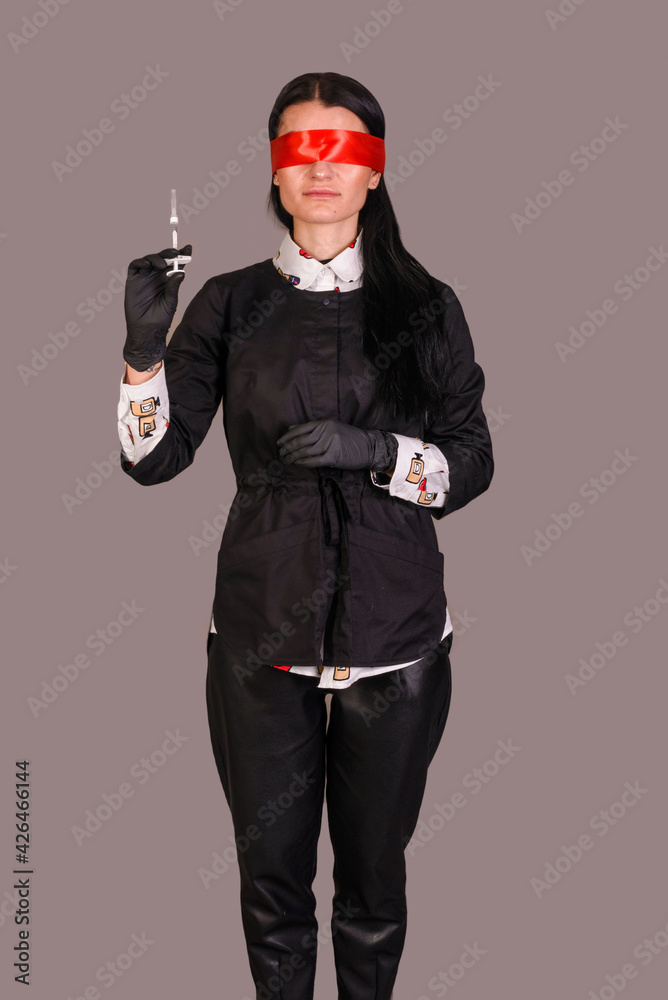 portrait of a blindfolded woman holding a syringe