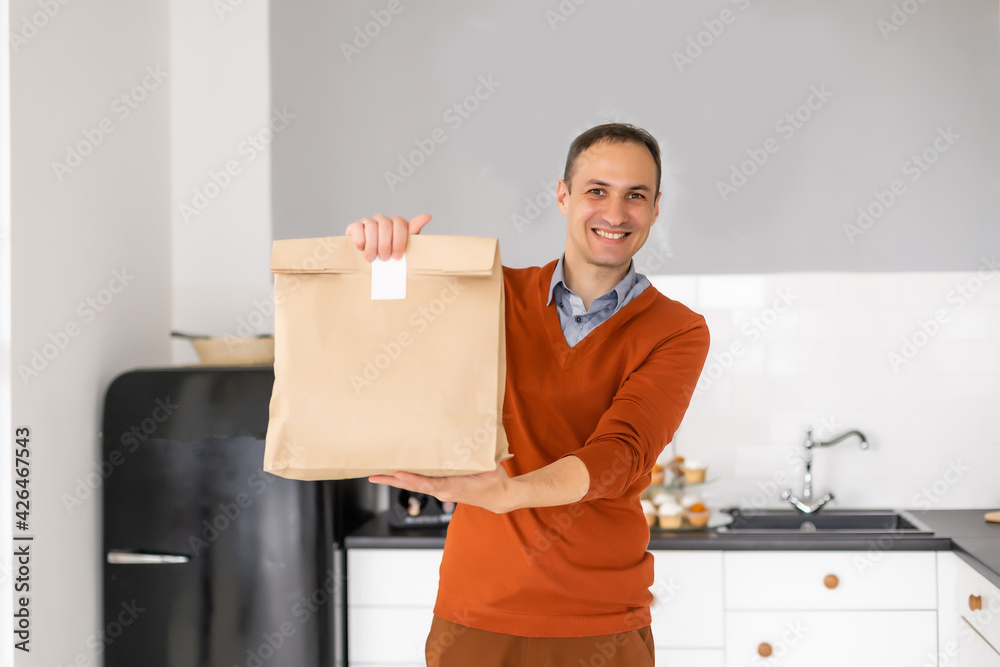 Cheerful delivery man. Happy young courier holding a delivery package. Cheerful delivery man. Happy young courier holding a delivery package.