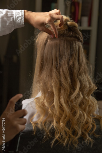Hair stylist making curls in a beauty salon