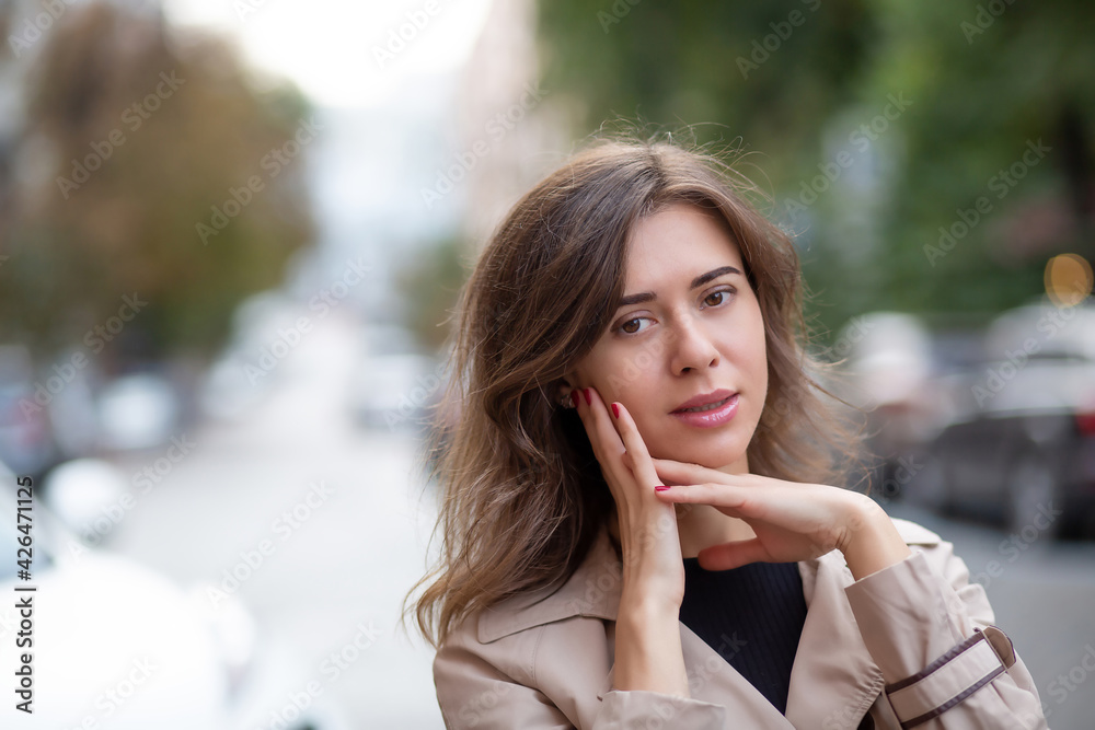 Tender brunette woman wears trench