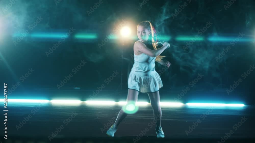 Sportswoman is playing tennis in a cloudy room Sportswoman is playing tennis in a cloudy room