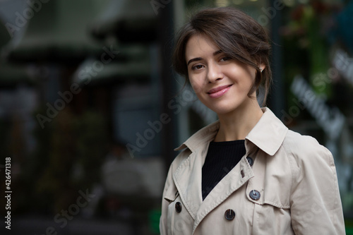 Smiling brunette woman wears trench