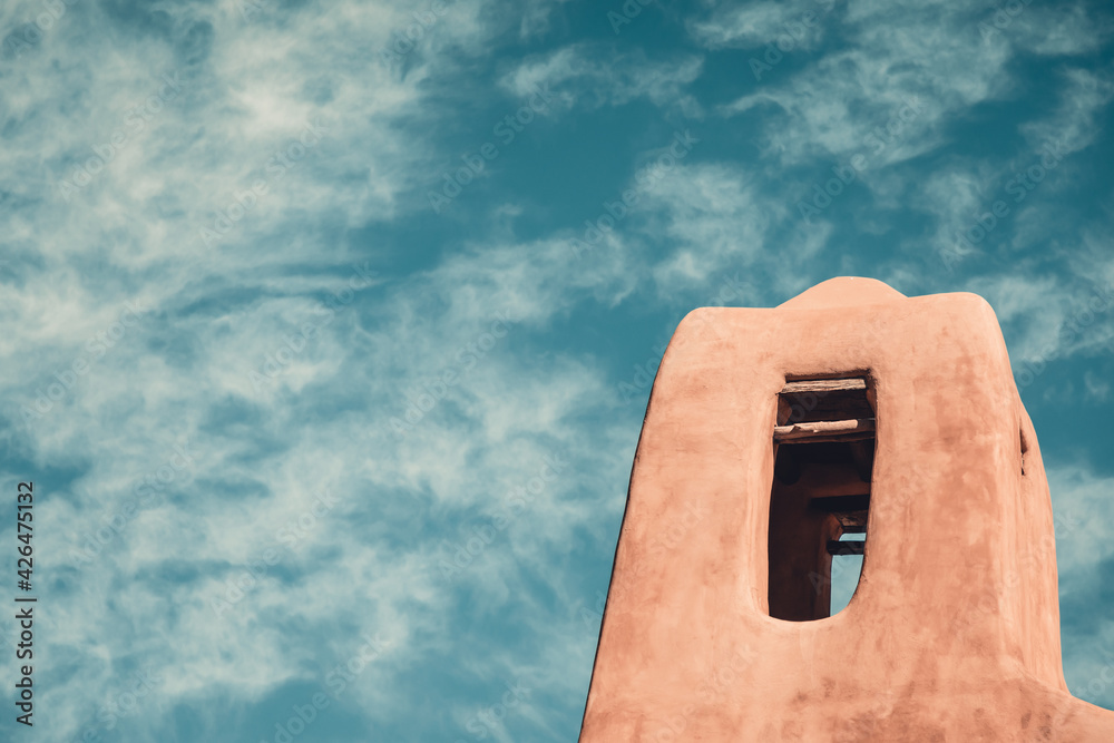 Fototapeta premium Tower of an old historic adobe church in New Mexico with a painterly sky