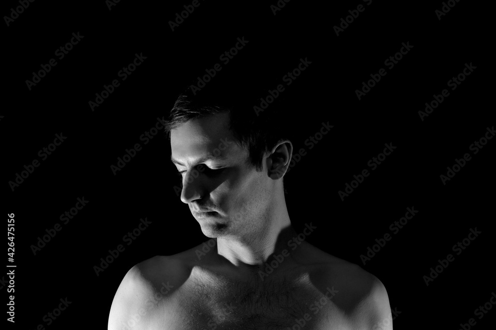 Naklejka premium black and white photo portrait of a guy, in dramatic lighting