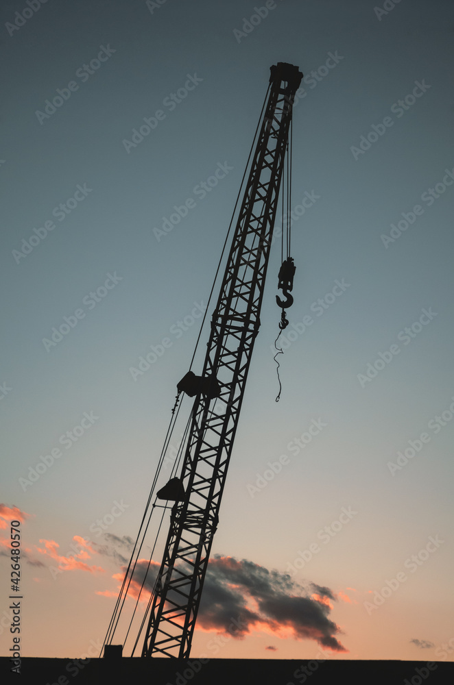 Construction crane in the evening at sunset. Construction crane in the evening at sunset.