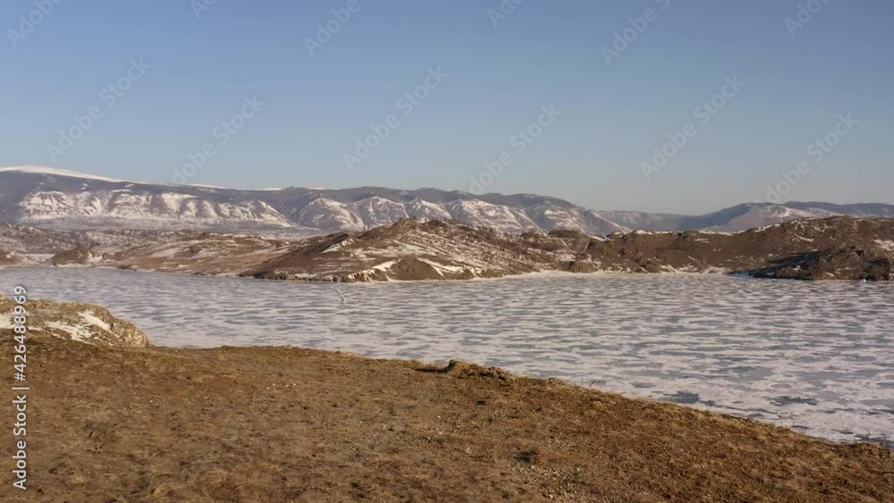 Flight along the coast with an opening view of the frozen Lake Baikal and the stairs leading to the coast from the water Flight along the coast with an opening view of the frozen Lake Baikal and the stairs leading to the coast from the water