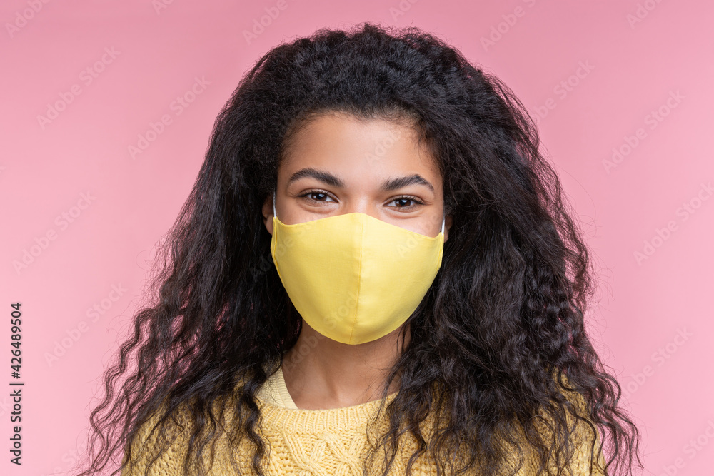 Close-up portrait of her she attractive pretty beautiful cute young dark-skinned woman wearing bright yellow protecting flu cold facial mask isolated over pink pastel background Close-up portrait of her she attractive pretty beautiful cute young dark-skinned woman wearing bright yellow protecting flu cold facial mask isolated over pink pastel background