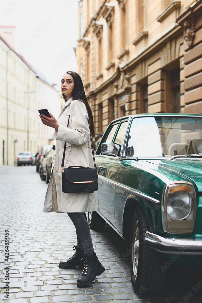 Fototapeta premium A woman on the street uses a mobile phone. online shopping. use of mobile applications.