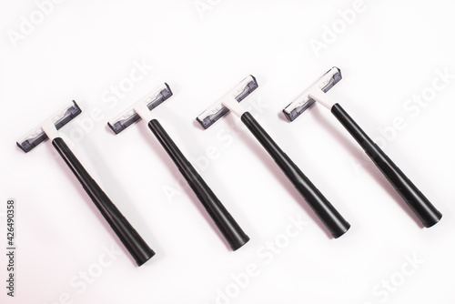 Four black disposable razors isolated on white background