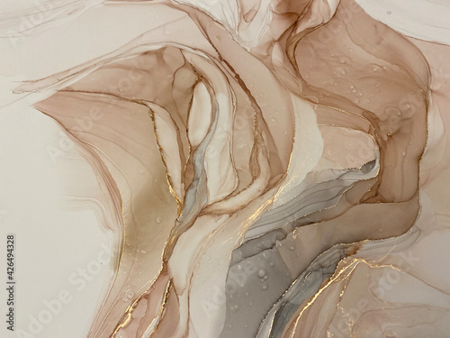 Abstract beige art with gold — pink background with brown, beautiful smudges and stains made with alcohol ink and golden pigment. Beige fluid art texture resembles petals, watercolor or aquarelle. © Luvricon