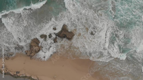 View from drone descending on waves breaking on submerged rocks at Calheta Porto Santo photo