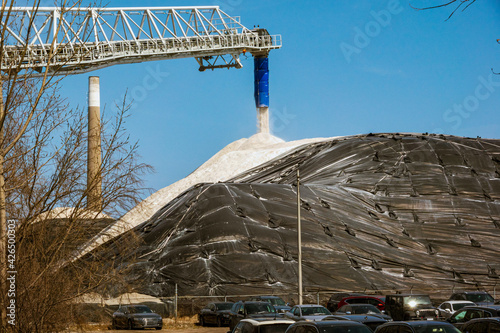 Fototapeta Naklejka Na Ścianę i Meble -  Road salt in huge  quantity is unloaded from a boom arm onto a tarp cover mound in the Port of Toronto