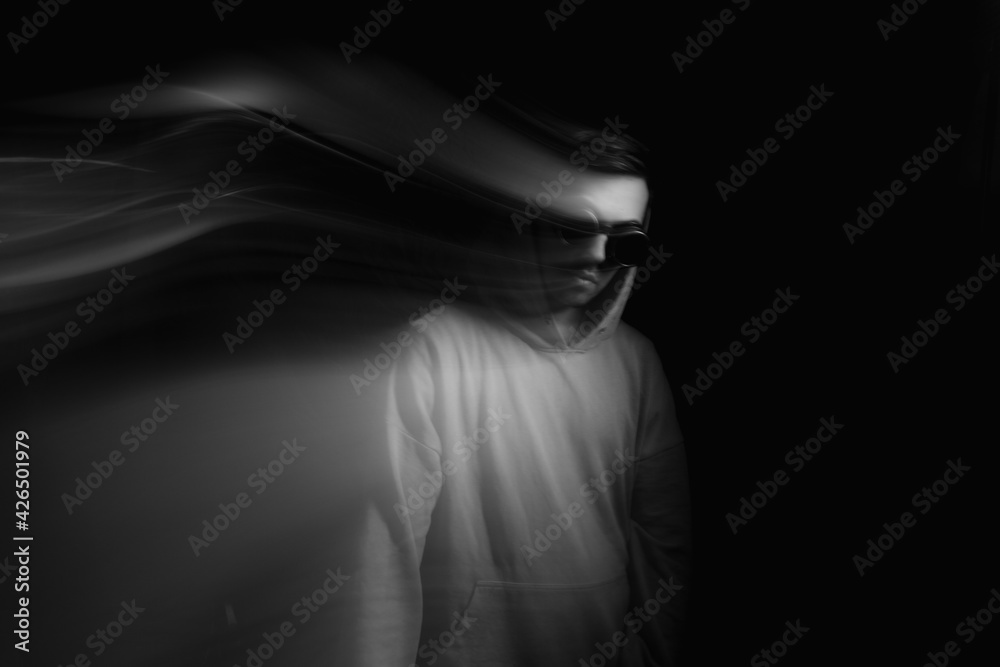 Fototapeta premium Facial face of a man in the dark. Art photography. Black-white art picture with a man. Portrait of man with blurred motion