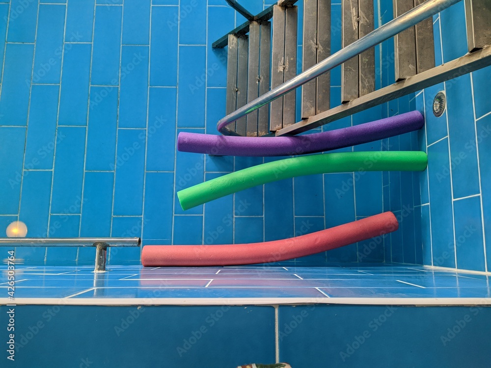 Naklejka premium ladder leading into the water of a pool