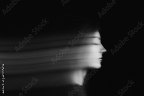 Blurred female portrait in the dark.