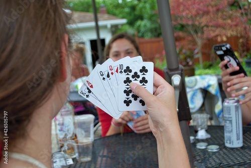 Over the shoulder view of a young woman playing cards photo