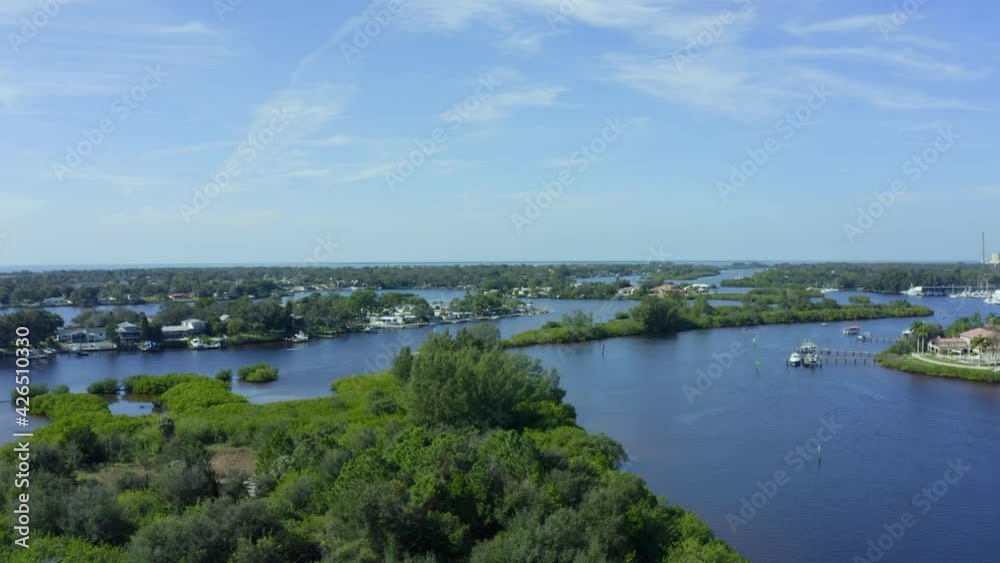 Slow Rising Aerial Pan of Waterfront Homes and Small Town Near a Bay Slow Rising Aerial Pan of Waterfront Homes and Small Town Near a Bay