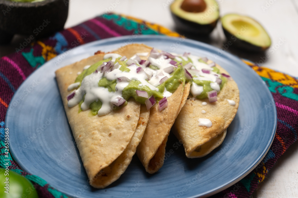 Fried tacos with guacamole and sour cream on white background. Mexican food Fried tacos with guacamole and sour cream on white background. Mexican food