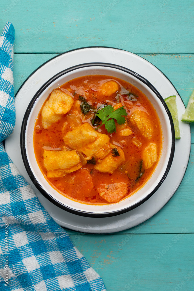 Fish soup with vegetables on turquoise background. Mexican food Fish soup with vegetables on turquoise background. Mexican food