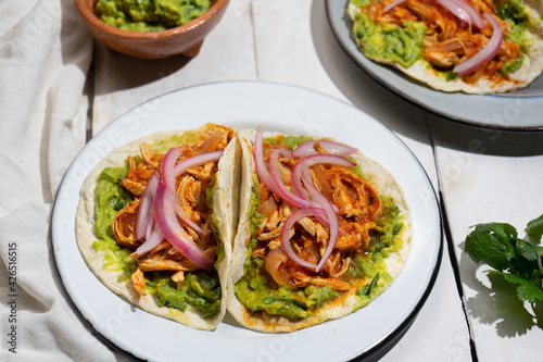 Chicken tinga tacos with guacamole and onion on white background. Mexican food