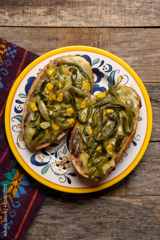 Molletes with poblano rajas and cheese on wooden background. Mexican food Molletes with poblano rajas and cheese on wooden background. Mexican food