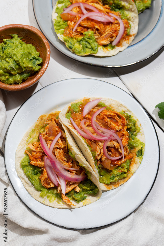 Chicken tinga tacos with guacamole and onion on white background. Mexican food Chicken tinga tacos with guacamole and onion on white background. Mexican food