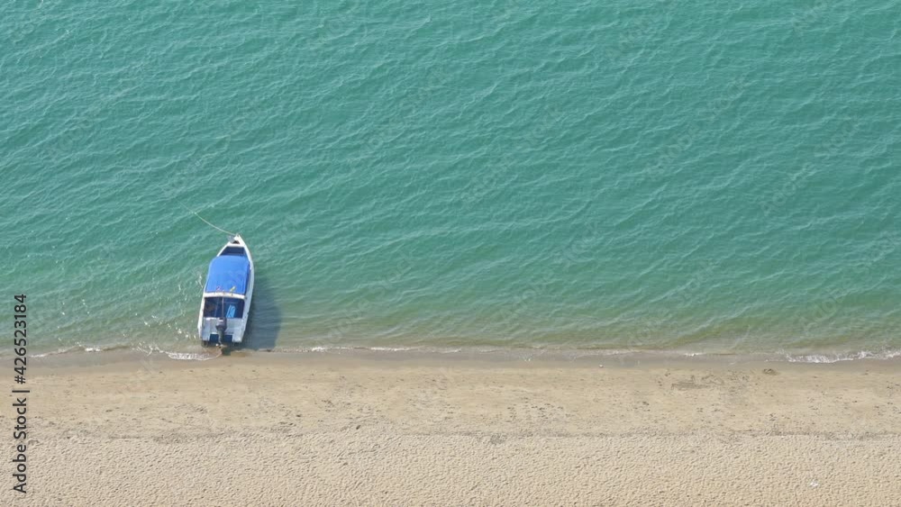 Small Tourist boat floating in the sea near the white sand beach top view 