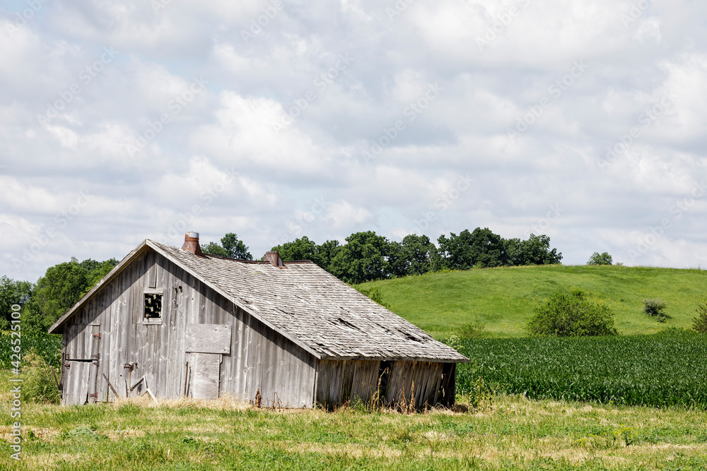 Old and Dilapidated Barn by a Field under a Cloudy Sky Old and Dilapidated Barn by a Field under a Cloudy Sky