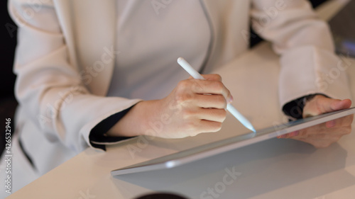 Close up view of businesswoman hand using digital tablet with stylus pen