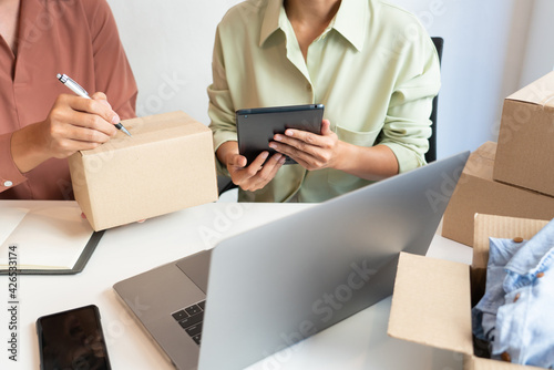 Asian business couple owner working at home with packing box of their online store prepare to deliver products to customers, alpha generation life style concept..