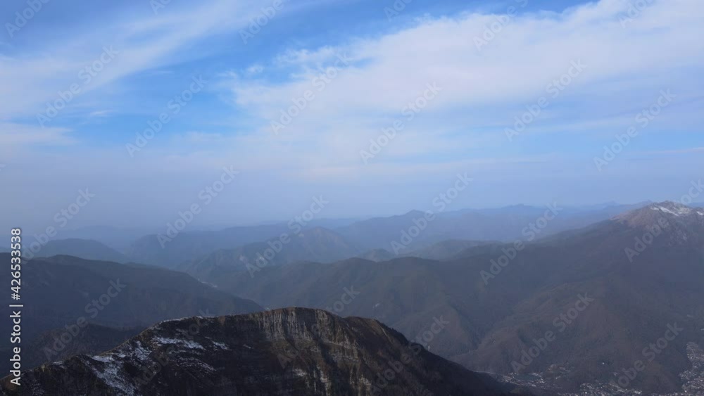 Gorgeous aerial view on mountain range with little bit of snow. Amazing natural landscape of hills from sky high. Beautiful blue sky on bright day. Concept of drone, background, fog. Gorgeous aerial view on mountain range with little bit of snow. Amazing natural landscape of hills from sky high. Beautiful blue sky on bright day. Concept of drone, background, fog.