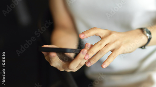 Female hand holding and finger touching on smartphone screen
