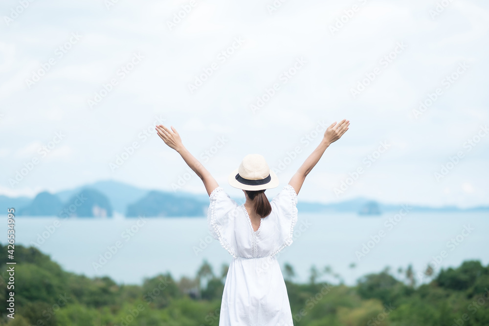 Happy traveler woman in white dress enjoy Beautiful view, alone Tourist with hat standing and relaxing over ocean. travel, summer and vacation concept Happy traveler woman in white dress enjoy Beautiful view, alone Tourist with hat standing and relaxing over ocean. travel, summer and vacation concept