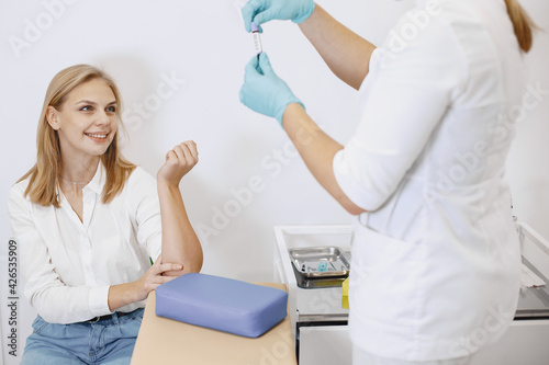 Nurse taking blood sample from patient at the doctors office