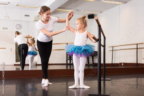 Young female choreographer and little girl in classical dance school © JackF