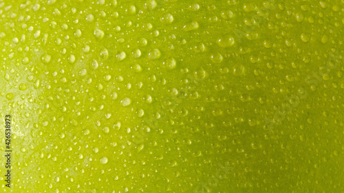 Close up water droplets on green apple skin. Macro shots