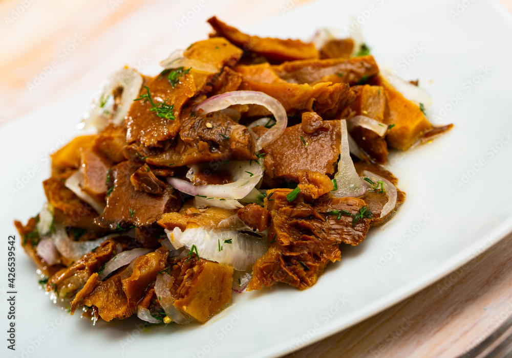 Plate of pickled red pine mushrooms (lactarius deliciosus) with onion