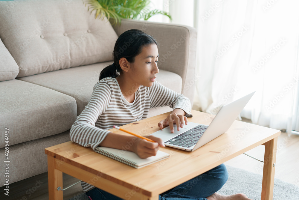 Asian girl learning online via the internet tutor on a laptop computer Asian girl learning online via the internet tutor on a laptop computer
